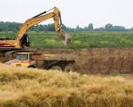 Op de voorgrond staat het laatste graan nog te rijpen. Na de oogst zal ook dit stuk worden afgegraven.  (28-6-2010 - Jan Dolmans)